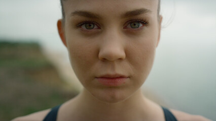 Closeup woman opening eyes standing on coast hill. Girl doing breathing exercise