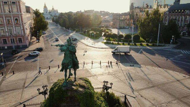 Drone flies around the Monument of Bogdan Khmelnitsky with Mykhailivsky Monastery on the background at dawn. Aerial view.