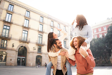 Obraz premium Two beautiful European couples in piggyback laughing and having fun. Friendship concept 