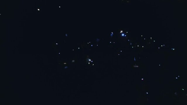 Aerial photography of people waving flashlights in the dark