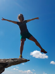 Woman balancing on the edge of a cliff