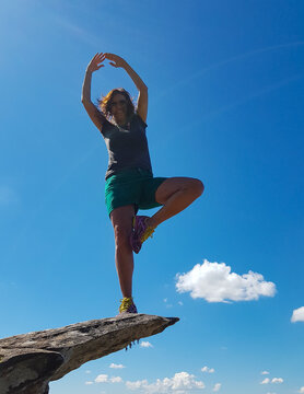 Woman Balancing On The Edge Of A Cliff