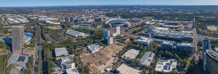 Fototapeta na wymiar Panoramic aerial drone view of Sydney Olympic Park, an Inner West suburb of Sydney, NSW, Australia on a sunny day 