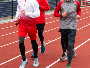 Fototapeta premium Small group of boys running together on a track
