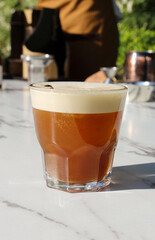 cup of organge cappuccino in the garden