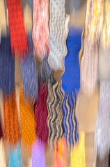 Abstract image of colourful neckties on a store rack melting toward the floor, nobody