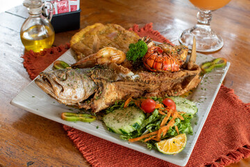 Whole fried fish with salad and fried plantain horizontal