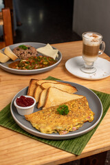 Amazing Omellete and toast with a capuccino and breakfast in background