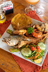 Whole fried fish with salad and fried plantain