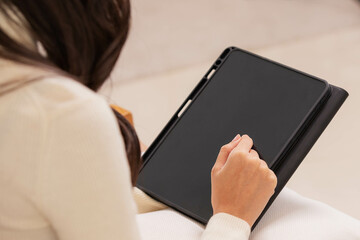 Asian girl using tablet playing game and social media or chatting with her friends.