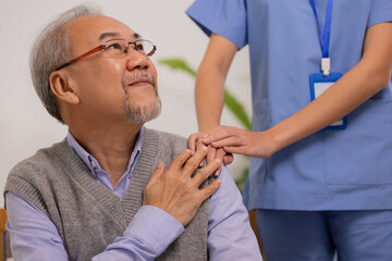Close up hand of hands of nursing aide holding and patting winkled hand of a patient.Domiciliary...