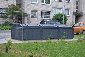 Modern garbage cans-containers in the courtyard of the house for separate waste collection - glass, plastic, and other materials. Recycling, environment, pollution. Vilnius, Lithuania.