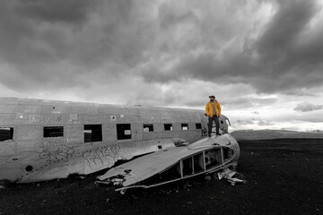 person standing on plane wreck in Vik, Iceland 