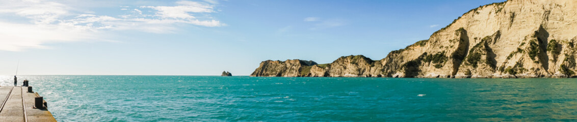 Fisherman standing on a pier in the sea