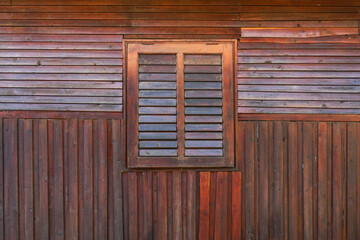 The wooden house wall and window are closed.