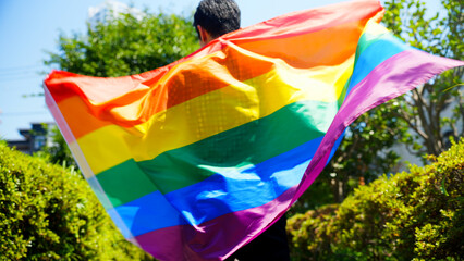 虹の旗を振る男性　LGBTイメージ