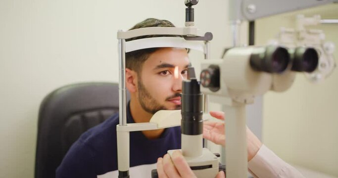 Optometrist detecting glaucoma and disorders on back of eyeball in a young man with eye exam. Healthcare medical testing eyesight on ophthalmoscope machine in a patient consult in hospital eye clinic