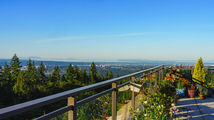 Early morning panoramic view across valley to distant high-rise buildings in Surrey, BC, and beyond to Straits of Georgia and Gulf Islands.