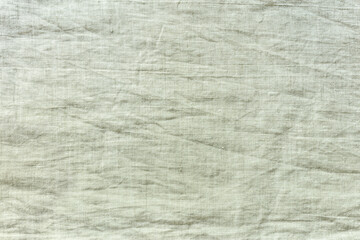 light beige wrinkled linen fabric background. natural cloth texture.