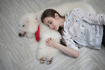 Smiling young attractive woman embracing cute puppy dog border collie on floor. Girl hugging new lovely member of family. Pet care and animals concept