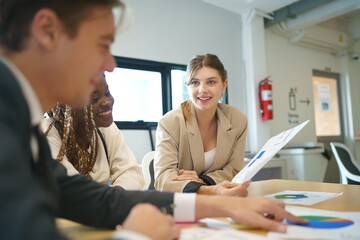 Obraz premium Image of young business people discussing document in paperwork data on desk at meeting