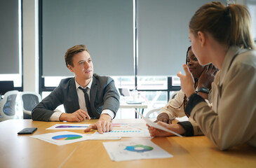 Image of young business people discussing document in paperwork data on desk at meeting