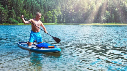 Foto op Canvas man rowing on a board on a calm sea © Sergey