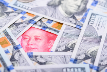 Trade war, trade tension between China and USA, business economic concept : Chinese renminbi CNY 100 yuan bill, portrait of Mao Zedong encircled by US USD dollar banknotes. Trade relationship at risk.