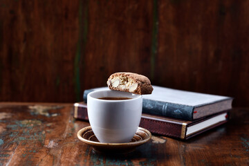 Cantuccini (Italian cookie) and a Cup of coffee on dark wooden background. Copy space	