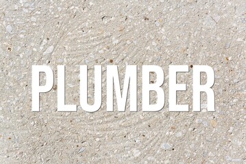 PLUMBER - word on concrete background. Cement floor, wall.