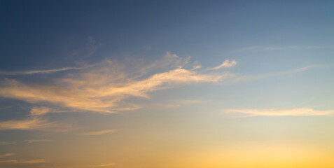 Naklejka na ściany i meble Colorful sunset sky background in the evening with orange sunlight clouds on blue sky, dusk