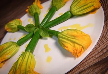Plate with fried zucchini flowers on color background. High quality photo