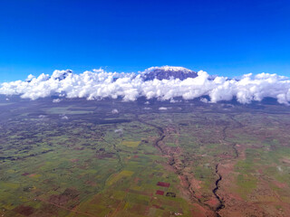 the top of Mount Kilimanjaro is shrouded in white clouds. bird's eye view