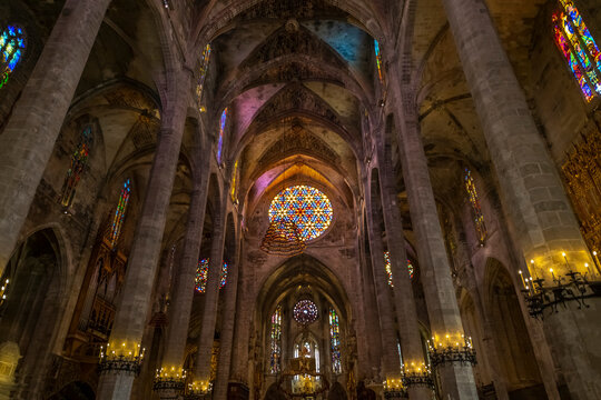 The ornate gothic interior with stained glass windows and imposing columns in the Palma de Santa Maria Cathedral of Palma, or La Seu, in the Mediterranean city of Palma de Mallorca Spain.