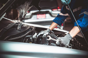 Car care maintenance and servicing, Close-up hand technician auto mechanic using the wrench to...