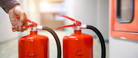 Fire extinguishers has hand engineer checking handle fire extinguisher to prepare fire equipment...