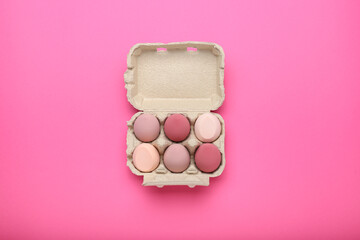 make-up sponges in an egg box on pink background. beauty concept, top view