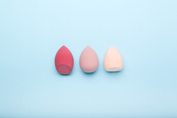 makeup sponges  on blue background. Beauty concept, top view