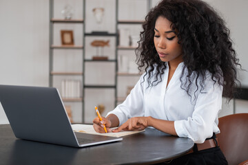 Black businesswoman take note, working in modern office room