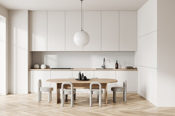 Light kitchen interior with eating table and chairs, kitchenware