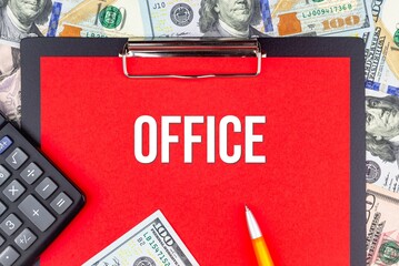 OFFICE - word on the background of money (dollars), a notepad and a pen with a calculator. Business concept (copy space).