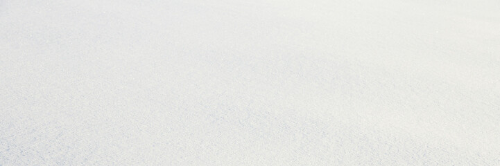 Natural snow texture. Smooth surface of clean fresh snow. Snowy ground. Winter background with snow patterns. Perfect for Christmas and New Year design. Closeup top view.