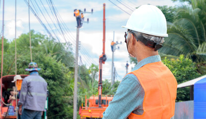 electrical engineer watching the work of workers