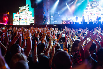 Fototapeta na wymiar Crowd raising their hands, dancing and enjoying great the concert. Summer holiday, vacation 