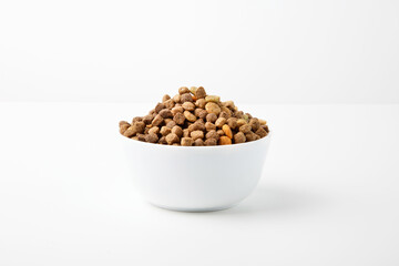 Food for cats and dogs in a white bowl on a white background.