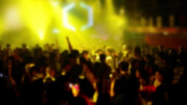 Out of focus abstract silhouette people dancing in a crowd. Flashes of light.