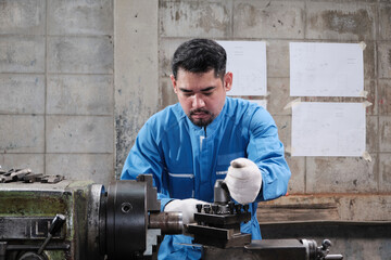 One professional Asian male industry engineer worker works in a safety uniform with metalwork...