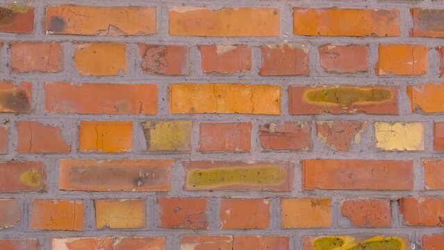 Rough old red and yellow brick wall while moving sideways