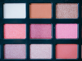 Beauty and Makeup concept from facial cosmetics, blush brush, highlighter palette and eye shadows with pink-tone for face make up on pink background.