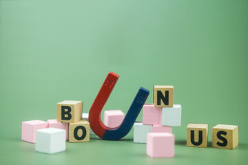 BONUS word made with wood blocks with horseshoe magnet, success after work hard, bonus money.